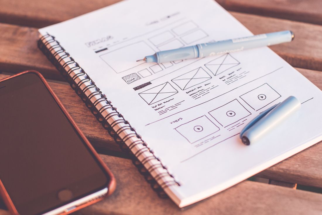 Designer sketching interface wireframes at a desk