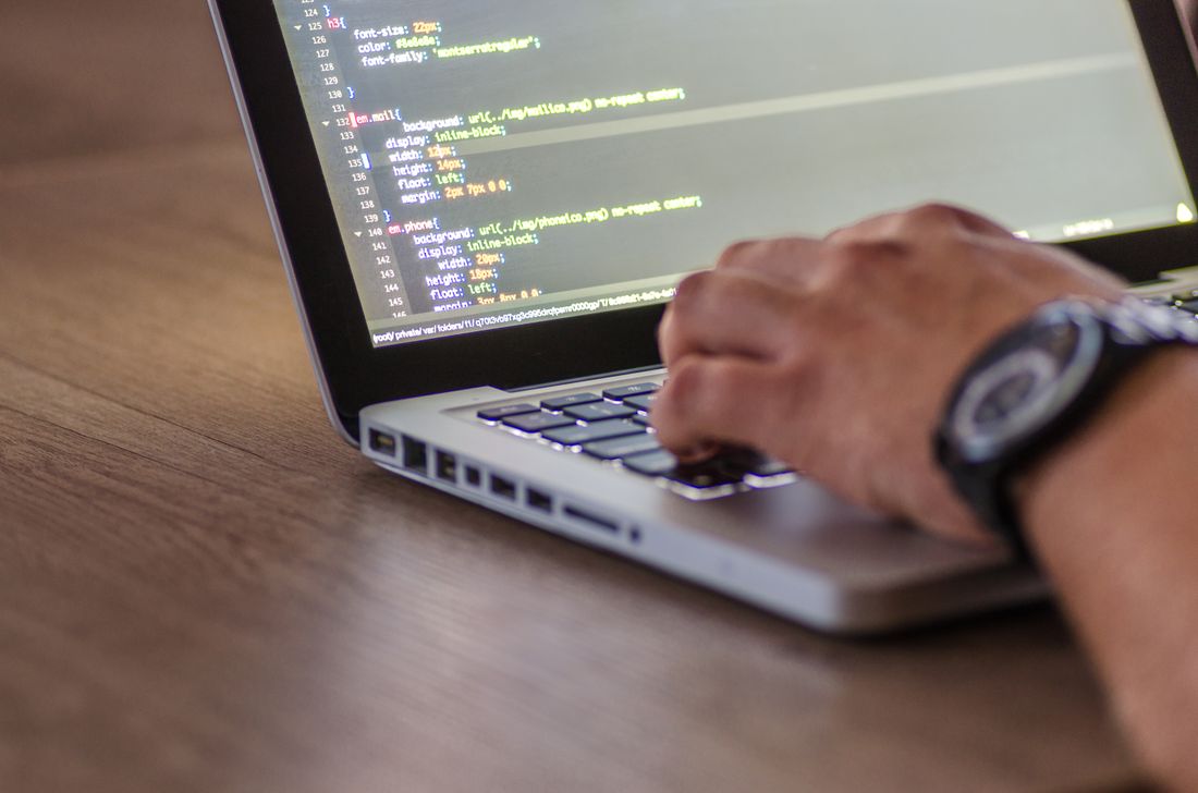Developer writing code on a laptop